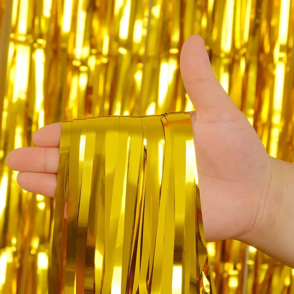 Une main tient un rideau en feuille d'or brillante devant un fond jaune vif.