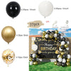 A collection of black, gold, and white balloons arranged in a decorative garland arch for a birthday celebration.