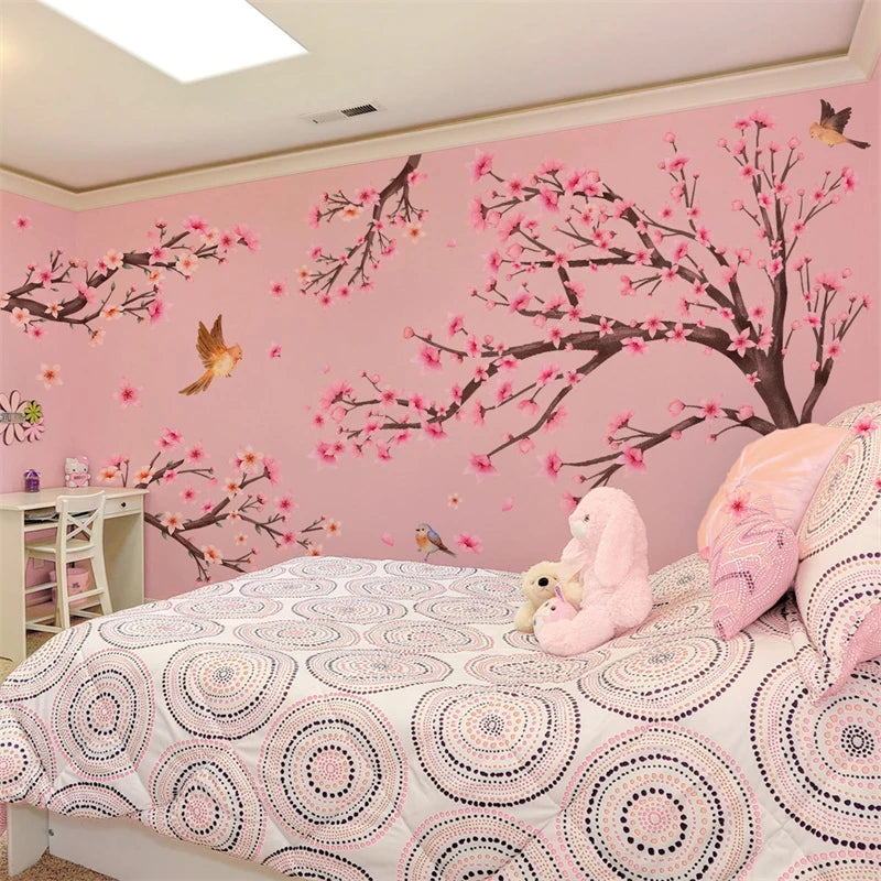 Pink cherry blossom tree wall stickers decorating a bedroom wall and bedding.
