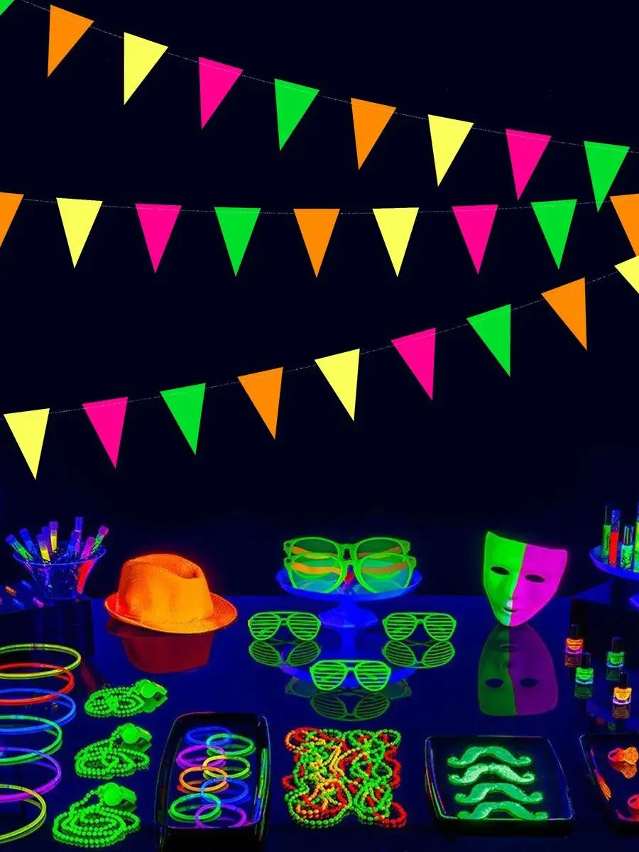 A collection of neon glow party banner flags and various glowing accessories displayed on a dark surface.