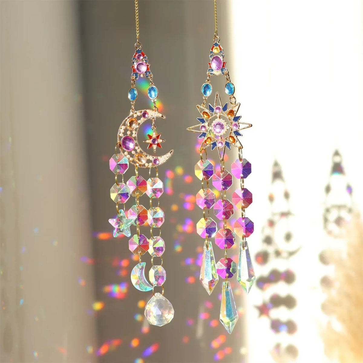 A pair of crystal rhinestone sun catchers hanging, featuring purple and blue stones, against a bright background.
