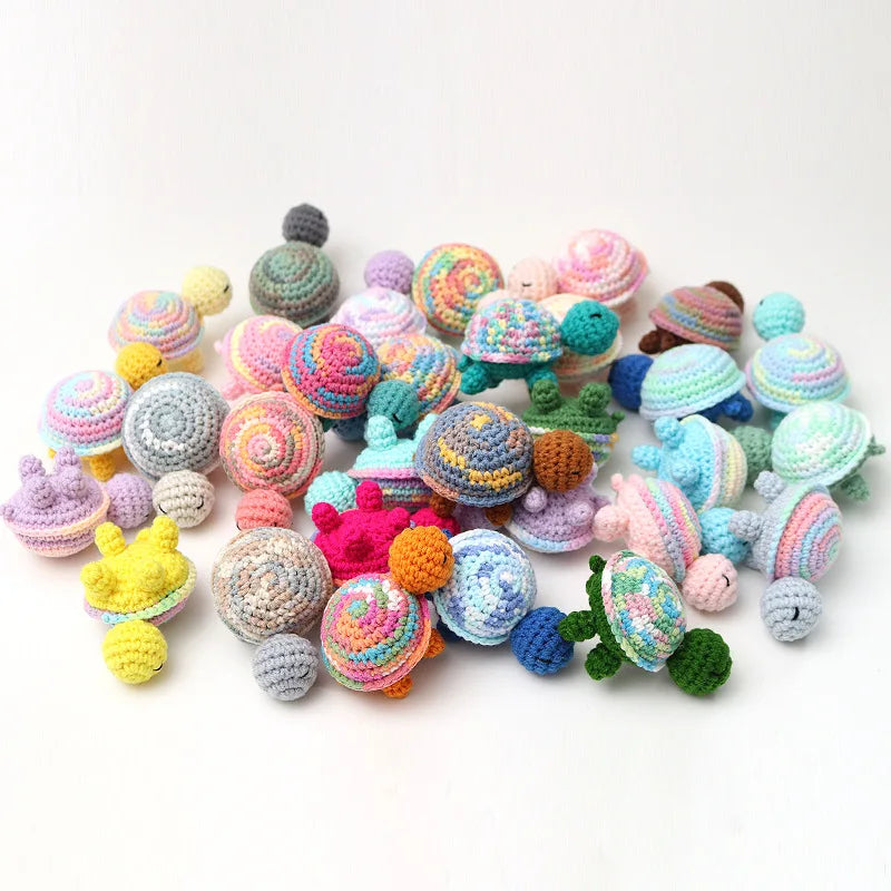 A collection of handmade crocheted turtle plush toys in various pastel and earthy colors.