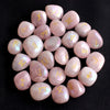 Colección de 25 piedras rúnicas de cristal natural en tonos rosa y transparente, dispuestas en patrón circular.