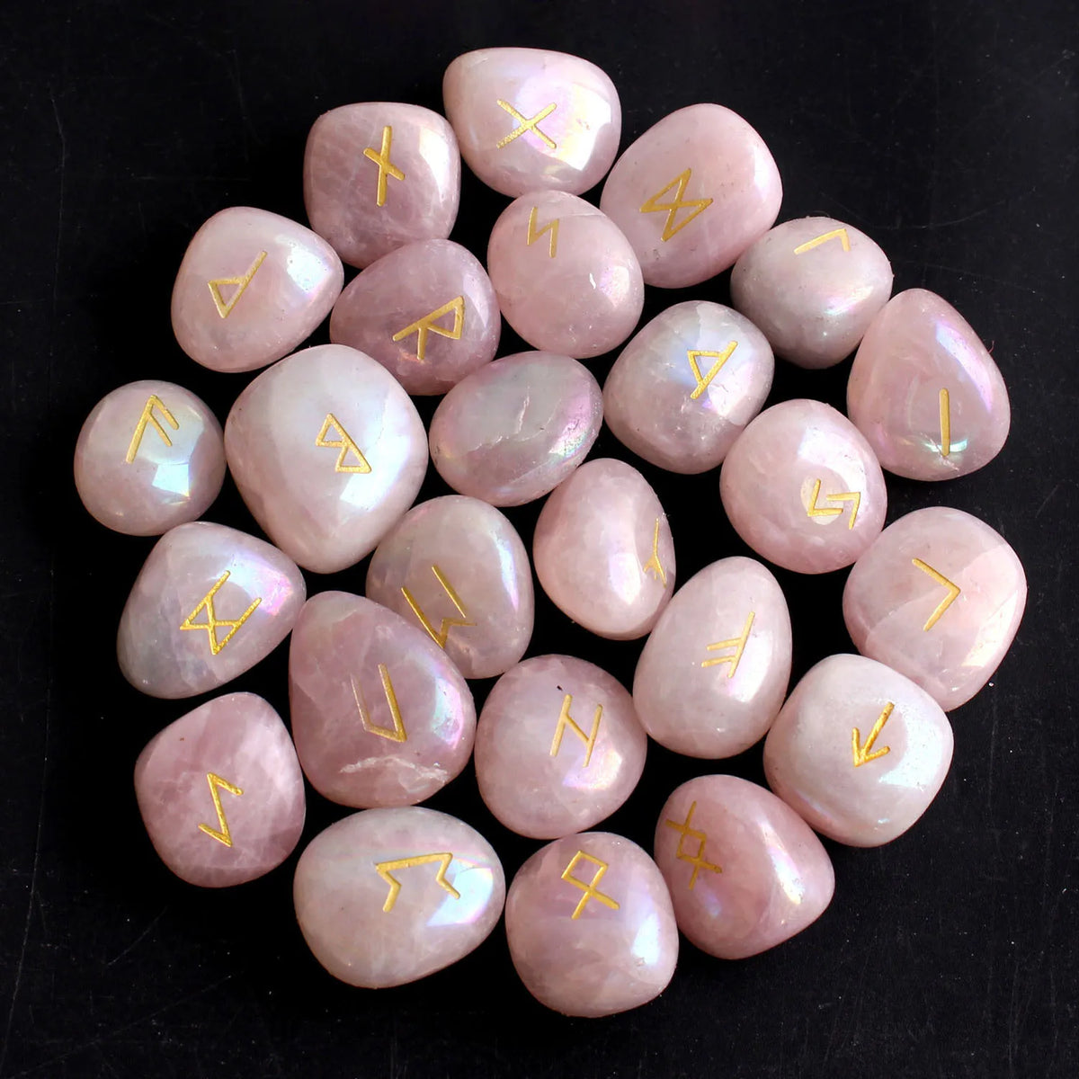 Colección de 25 piedras rúnicas de cristal natural en tonos rosa y transparente, dispuestas en patrón circular.