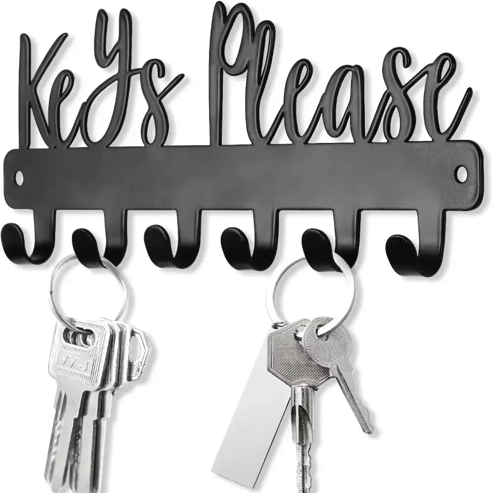 A black wall-mounted metal key holder with hooks and several keys attached.