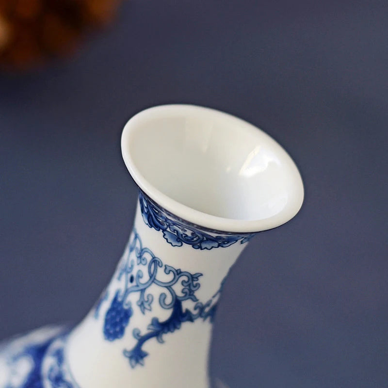 Close-up of a white ceramic flower vase with blue floral patterns and a flared opening.