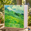 A green landscape painting on a laminated photo album with the text Cherished Moments