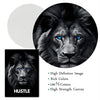 A close-up black and white photograph of a majestic lion's face with striking blue eyes, printed on a canvas.