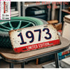 A distressed metal tin sign with the year 1973 and limited edition text displayed on a wooden surface.