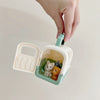 A hand opens a light green plastic playset box revealing a basket with three small stuffed animal pets.