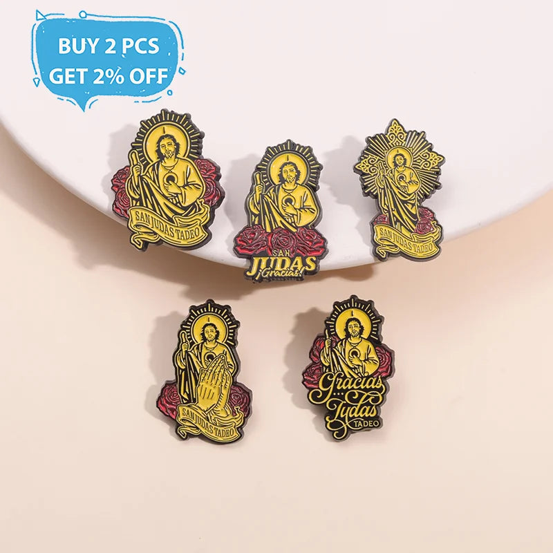 Two gold enamel pins featuring the image of Saint Judas Tadeo with surrounding text on a white background.