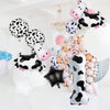 A set of cow print number balloons featuring black and white spots in various sizes and shapes.