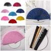 A collection of elegant wooden hand fans in various colors including pink, red, blue, and yellow.
