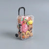 A clear plastic suitcase figure filled with small, soft-glow capybara mini figures.
