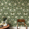 Gros plan d'un papier peint autocollant bohème floral avec de la verdure et des fleurs blanches sur un mur.