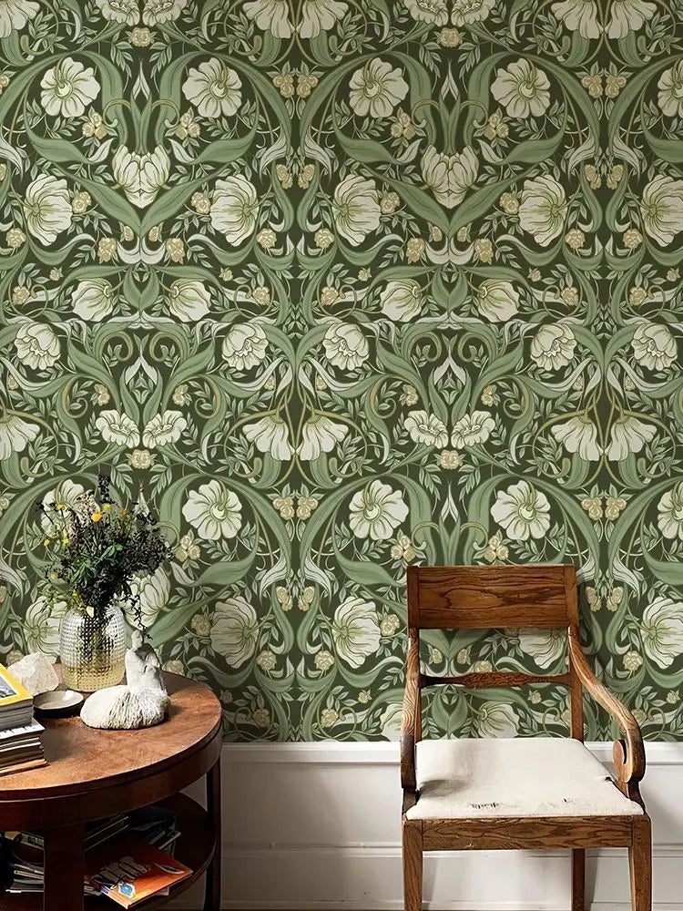 Gros plan d'un papier peint autocollant bohème floral avec de la verdure et des fleurs blanches sur un mur.