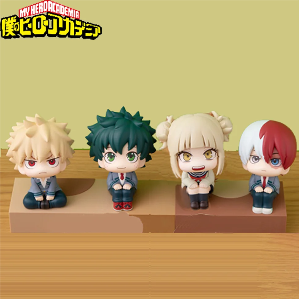 Four chibi collectible figures of My Hero Academia characters including Izuku, Bakugo, Shoto, and Toga displayed on a wooden 