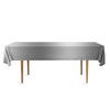 A rectangular gray disposable tablecloth displayed on a wooden table.