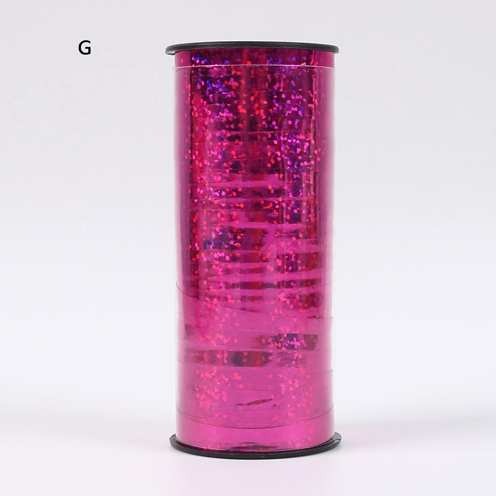 A roll of glitter curling ribbon in bright pink, used for gift wrapping and party decor.