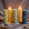 A collection of nine pillar candles in various colors and designs featuring celestial and mystical symbols