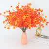A vibrant bouquet of orange and yellow artificial daisies used for autumn home decor.