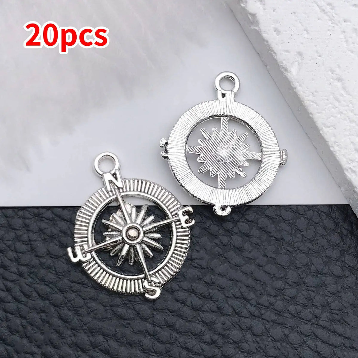 20 pieces of vintage ship anchor charms for jewelry making displayed on a dark surface.