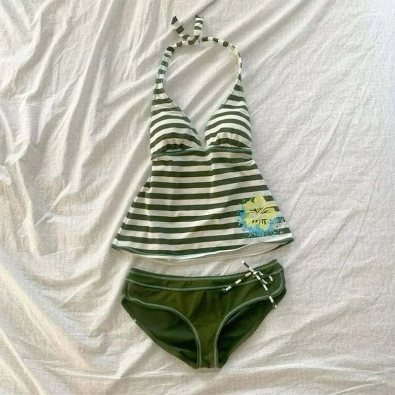 A striped sleeveless top with a tie detail and matching green bottoms laid flat on a white surface.