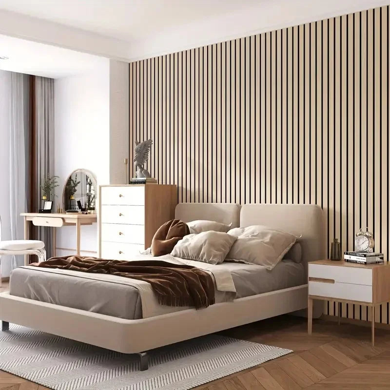A bedroom featuring a bed with light beige linens against a wall covered in vertical wood grain panels.