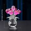 A bouquet of pink crystal roses displayed in a clear glass vase on a dark surface.