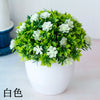 Un pot de bonsaï artificiel décorant avec du feuillage vert vif et des fleurs blanches.