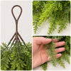 Artificial Christmas teardrop swag made of green Norfolk pine needles with a brown hanger.