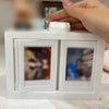 A white 3D rotating photo holder with two clear display pockets is being held by a hand.