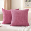 Two solid pink linen pillows resting on a white textured surface.