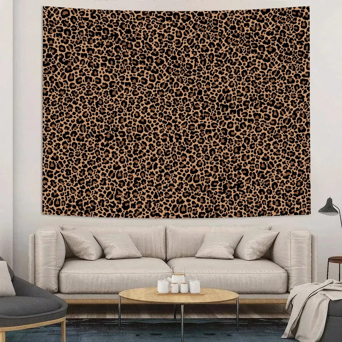 A large tapestry wall hanging featuring a brown and black leopard print on a beige wall above a light gray sofa.