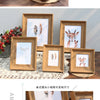 A set of wooden photo frames with resin prints displayed on a wooden surface.