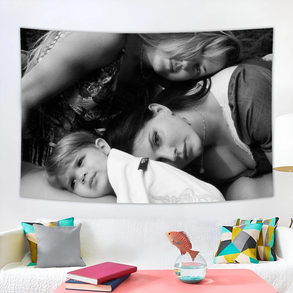 Fotografía en blanco y negro de una mujer y un niño acostados, con un tapiz decorativo de la bandera de Lana.