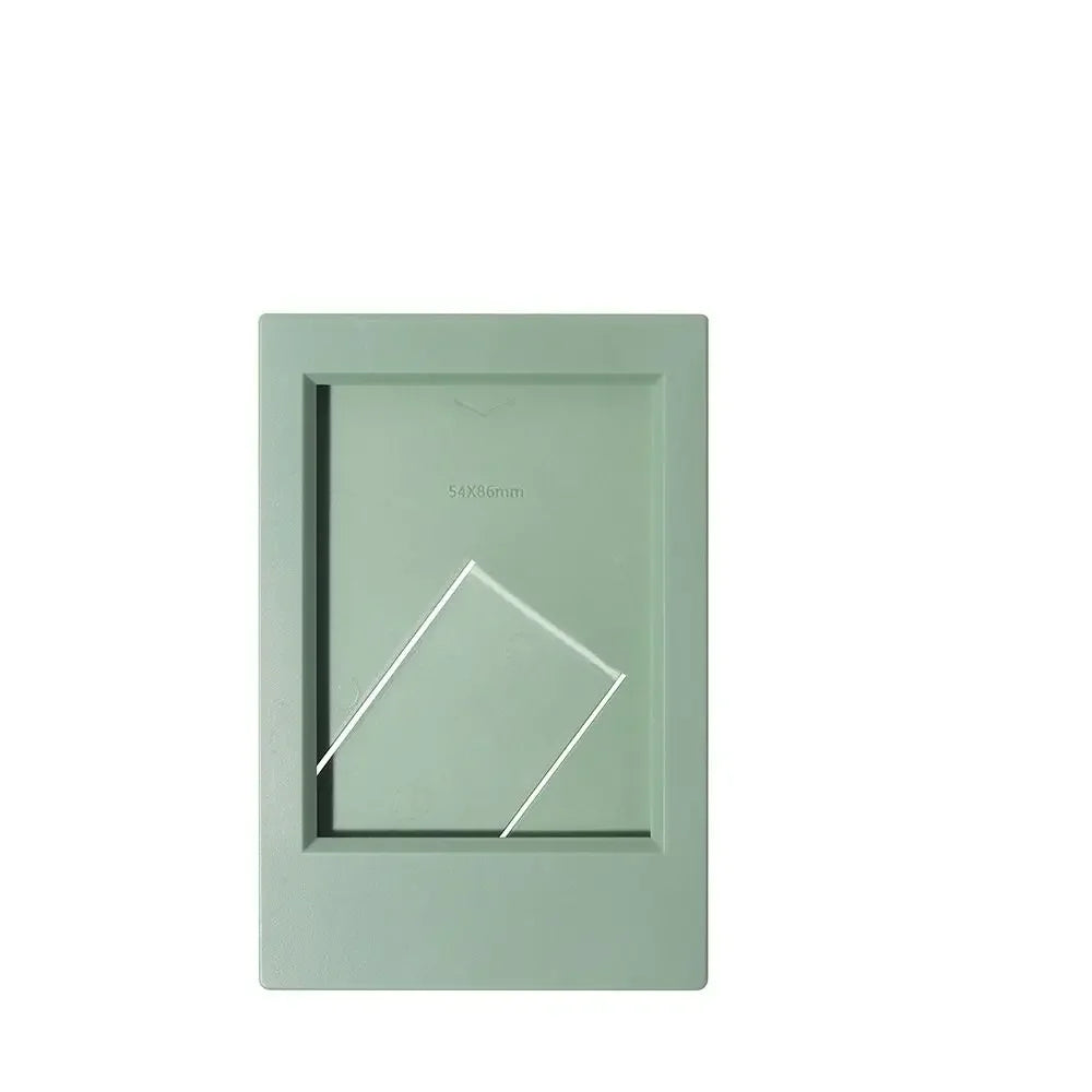 A rectangular, light green mini film frame with a white diagonal cutout for instant photos.