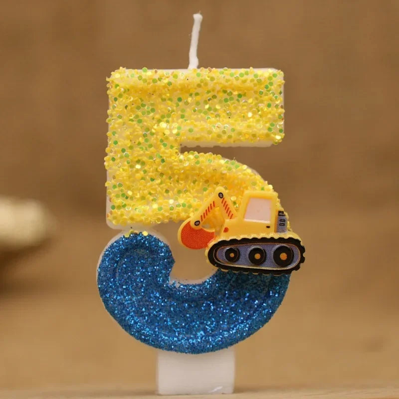 A birthday candle shaped like the number 5 made of yellow glitter and topped with a small construction excavator figure.