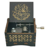 A dark wooden box containing a metal music box with an engraved design of a wolf and stars.