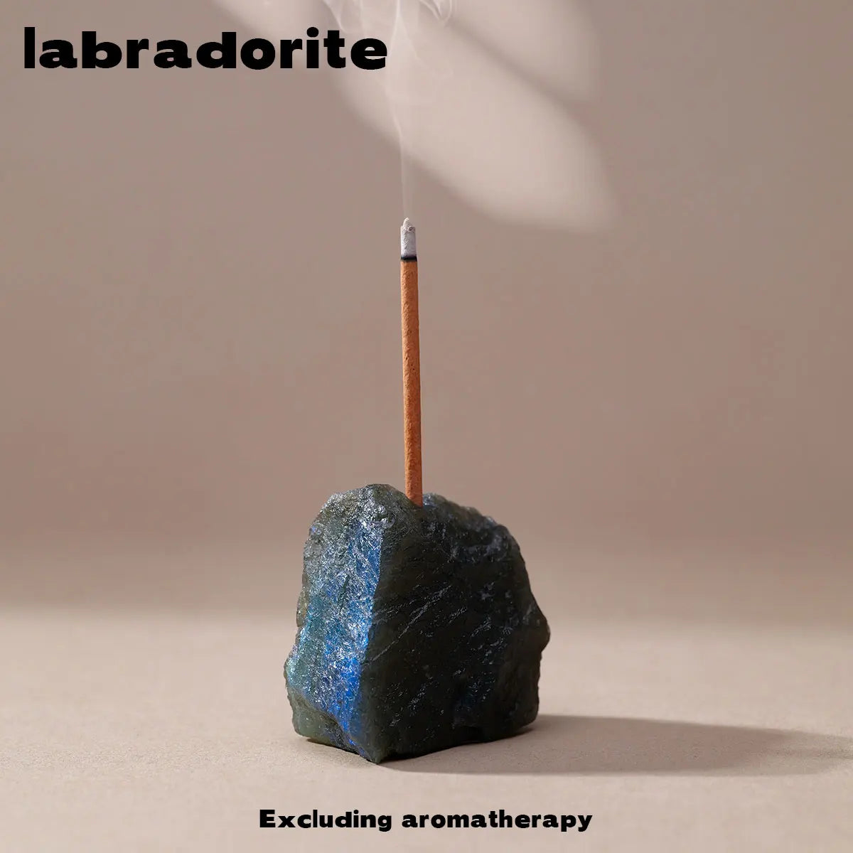 A dark blue crystal resting on a wooden incense stick, used for labradorite aromatherapy.