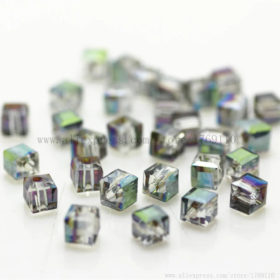 A collection of square cut glass crystal beads in various shades of blue and green.