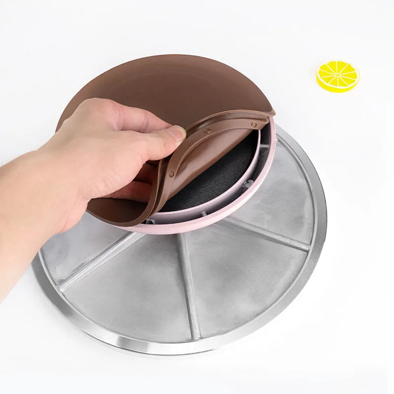 A hand is placing a brown cake turntable onto a silver aluminum base.
