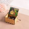 A hand-cranked wooden music box featuring a Totoro design, set against a light background.