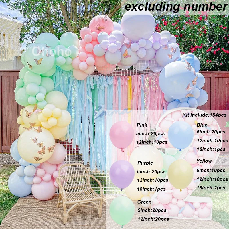 A colorful balloon garland kit featuring pink, purple, and blue balloons arranged on a wooden surface.