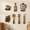 A collection of vintage wooden coffee utensils including a decanter, spoon, fork, and knife mounted on a white wall.