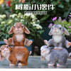A pair of hand-painted resin rabbit garden statues, one brown and one gray, displayed outdoors.