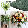 A close-up of artificial green flower stems and a large bouquet of mixed red, yellow, and white roses and greenery.