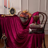 Burgundy red velvet rectangular tablecloth set for elegant dining featuring candelabras and decorative items