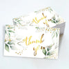 Ein Set eleganter Blumen-Dankeschönkarten mit Gold-Kalligrafie und Aquarellgrün auf weißem Papier.