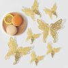 A set of three 3D gold butterfly wall decor pieces scattered on a white background.